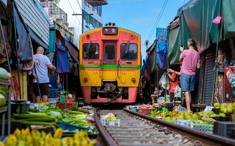Một chuyến tàu chạy qua chợ đường sắt Maeklong
