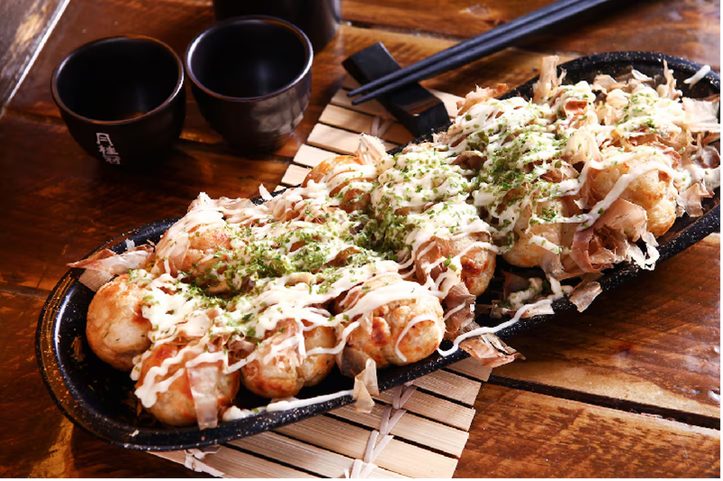 Takoyaki, một món ăn đường phố nổi tiếng ở Osaka, là những viên chiên nhỏ chứa đầy những miếng mực. Ảnh / 123rf